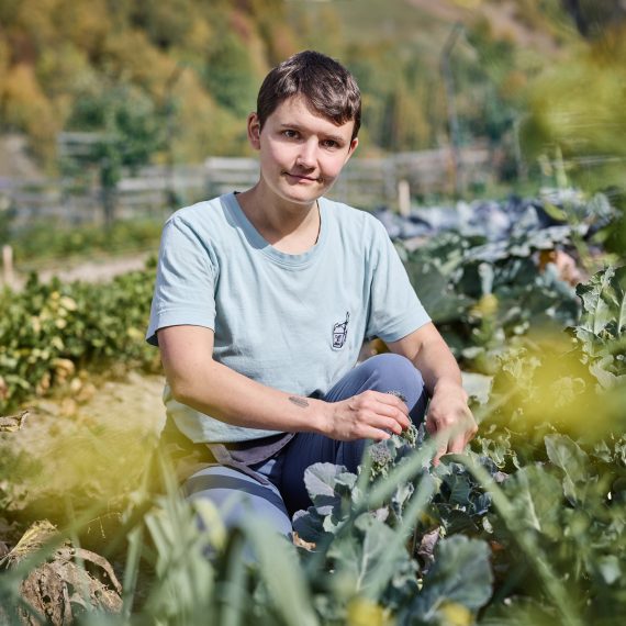 Portrait von Lisa Jankovics bei der Ernte im Garten des Hotel medelina in Curaglia.
